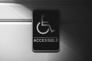ADA compliant signs mounted next to doors in a commercial building hallway - ada sign installation guidelines