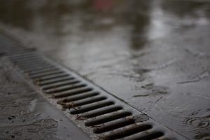 French drain installation in a waterlogged commercial parking lot